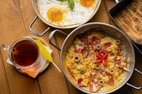 Breakfast spread with fried eggs, omelet, and tea.